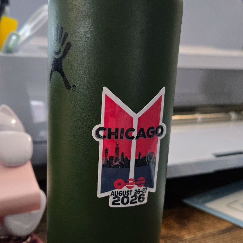 Green water bottle with Chicago 2026 logo on a wooden surface