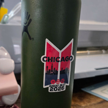 Green water bottle with Chicago 2026 logo on a wooden surface